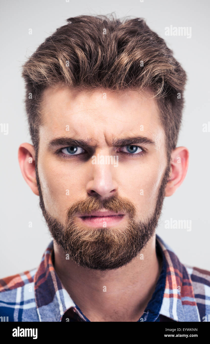 Closeup portrait of a serious man looking at camera isolated on a white ...