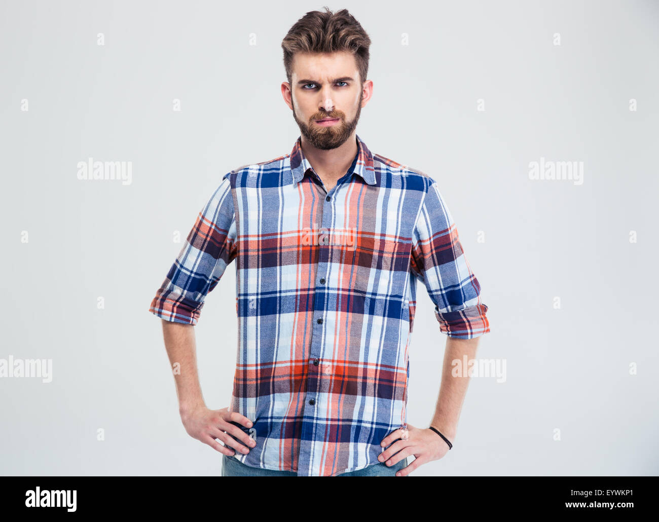 Portrait of a young serious man looking at camera isolated on a white ...