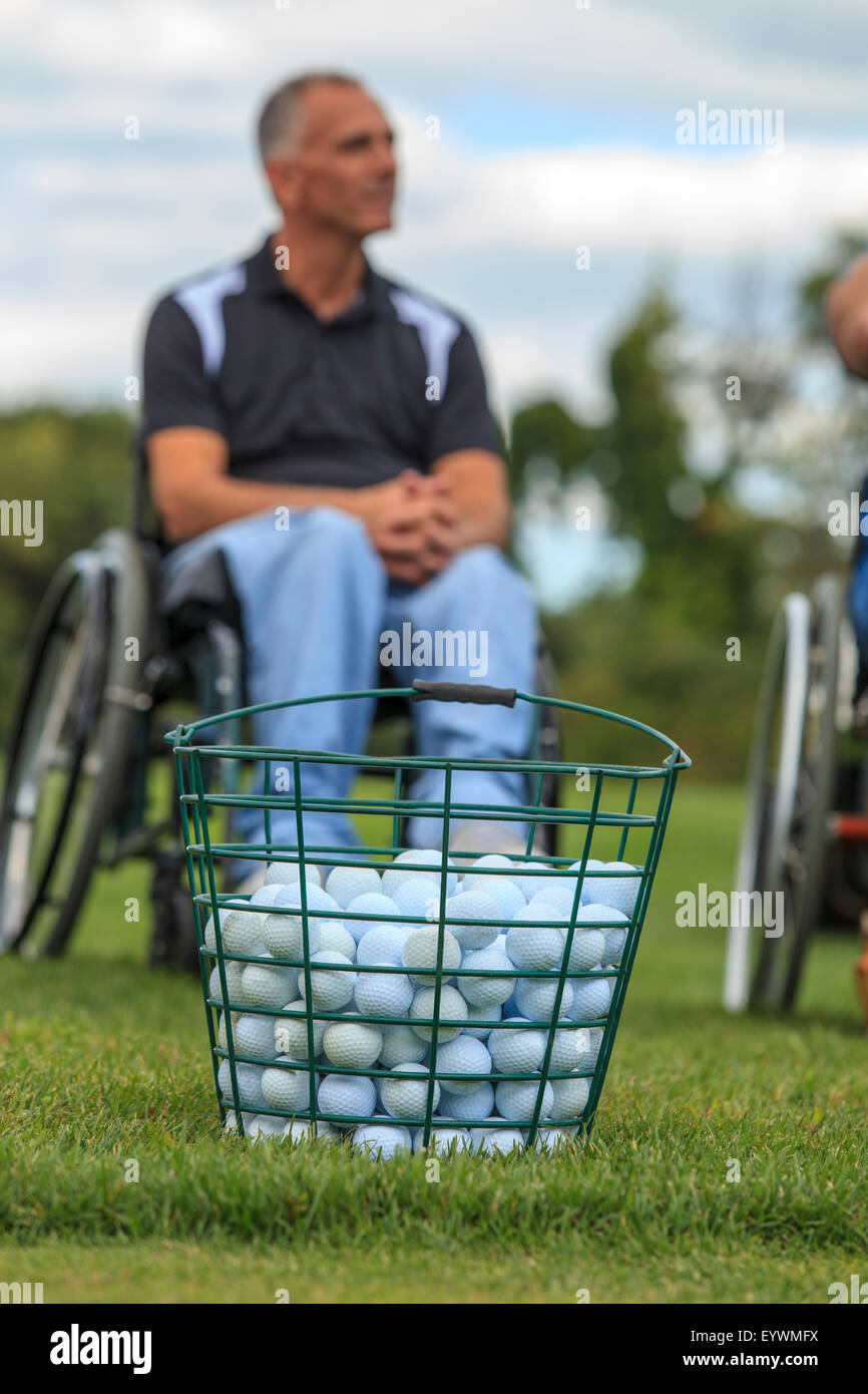 Man in wheelchair with spinal cord injuries waiting to play golf Stock Photo