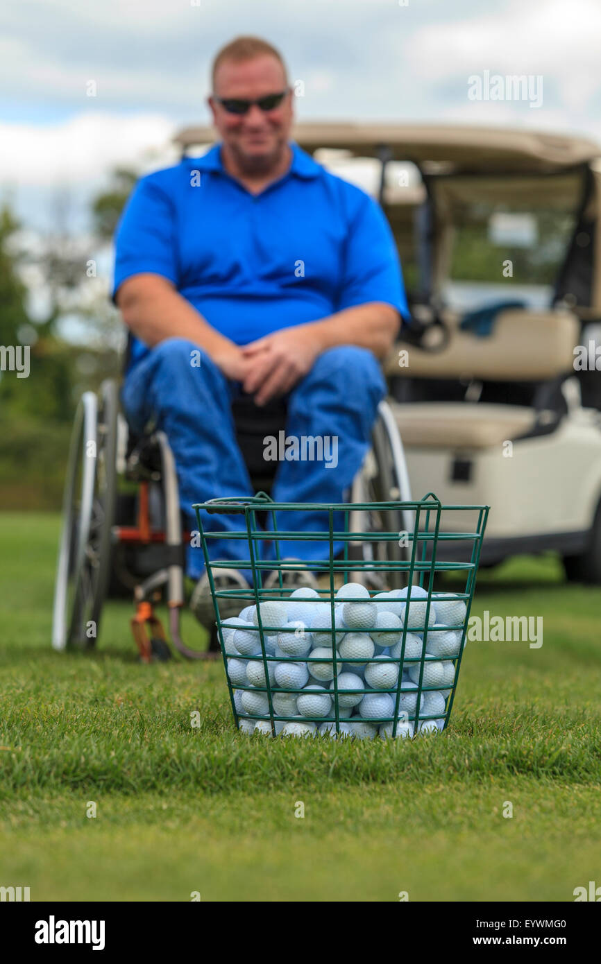 Man in wheelchair with spinal cord injuries waiting to play golf Stock Photo
