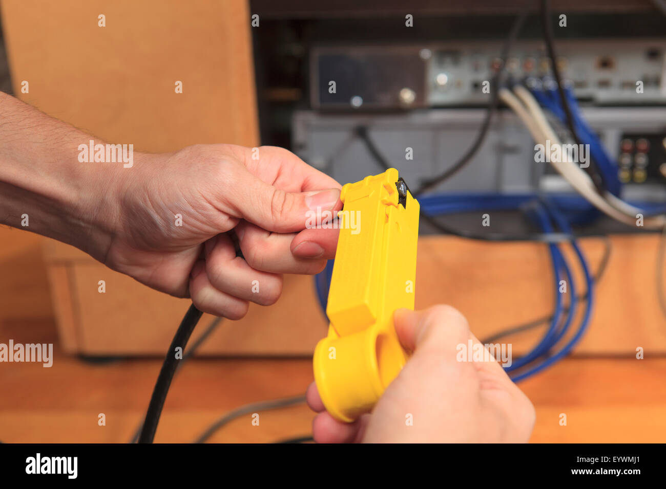 Cable installer using a tool to remove the outer insulation sheath from