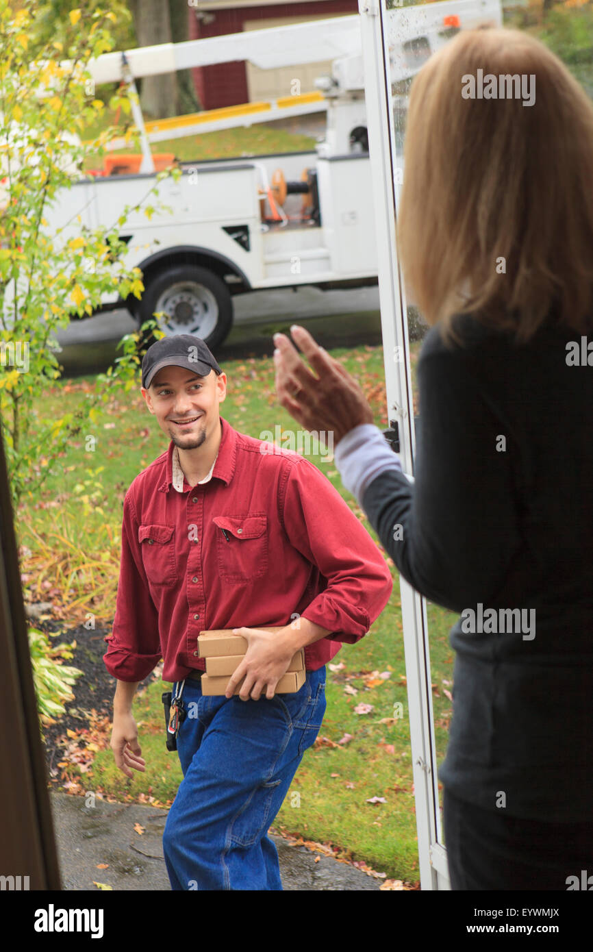 Cable installer leaving and waving to homeowner Stock Photo Alamy
