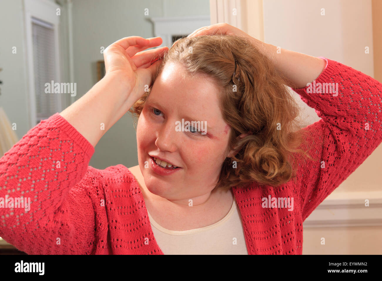 Young woman with Autism fixing her hair Stock Photo