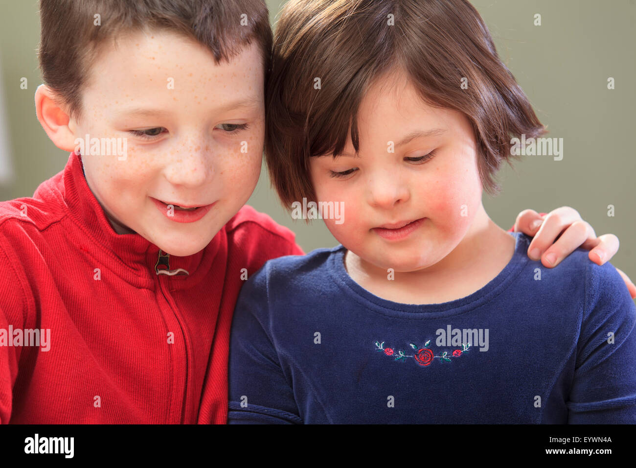 Little girl with Down Syndrome with her brother Stock Photo