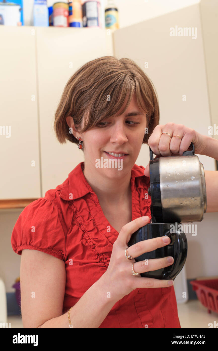Young blind woman making coffee in her kitchen Stock Photo Alamy