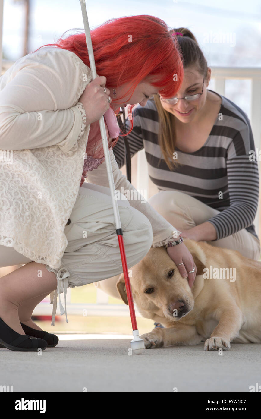 Two women with visual impairments, one with a service dog and one with