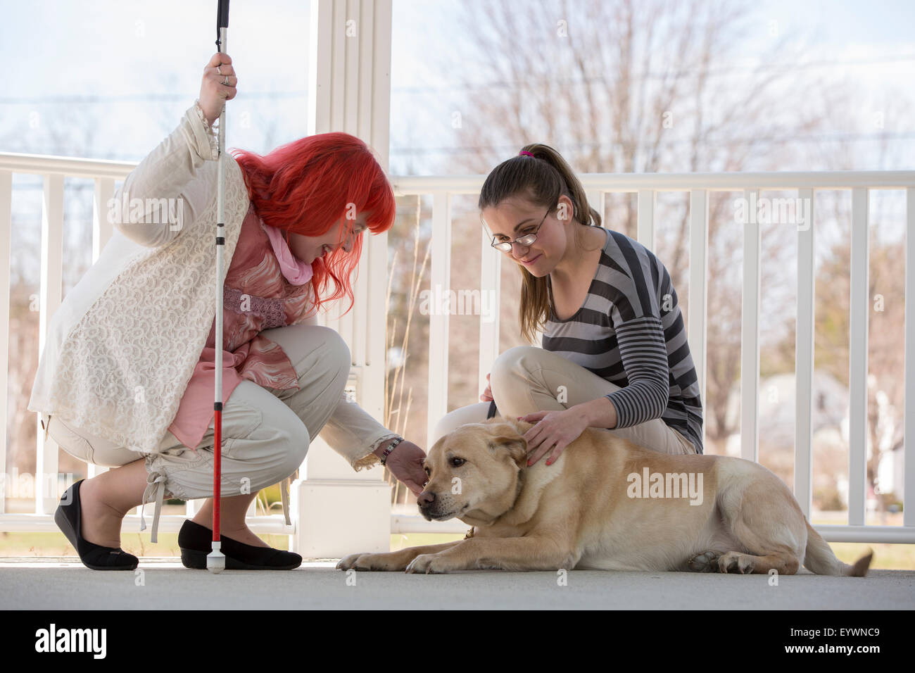 Two women with visual impairments, one with a service dog and one with
