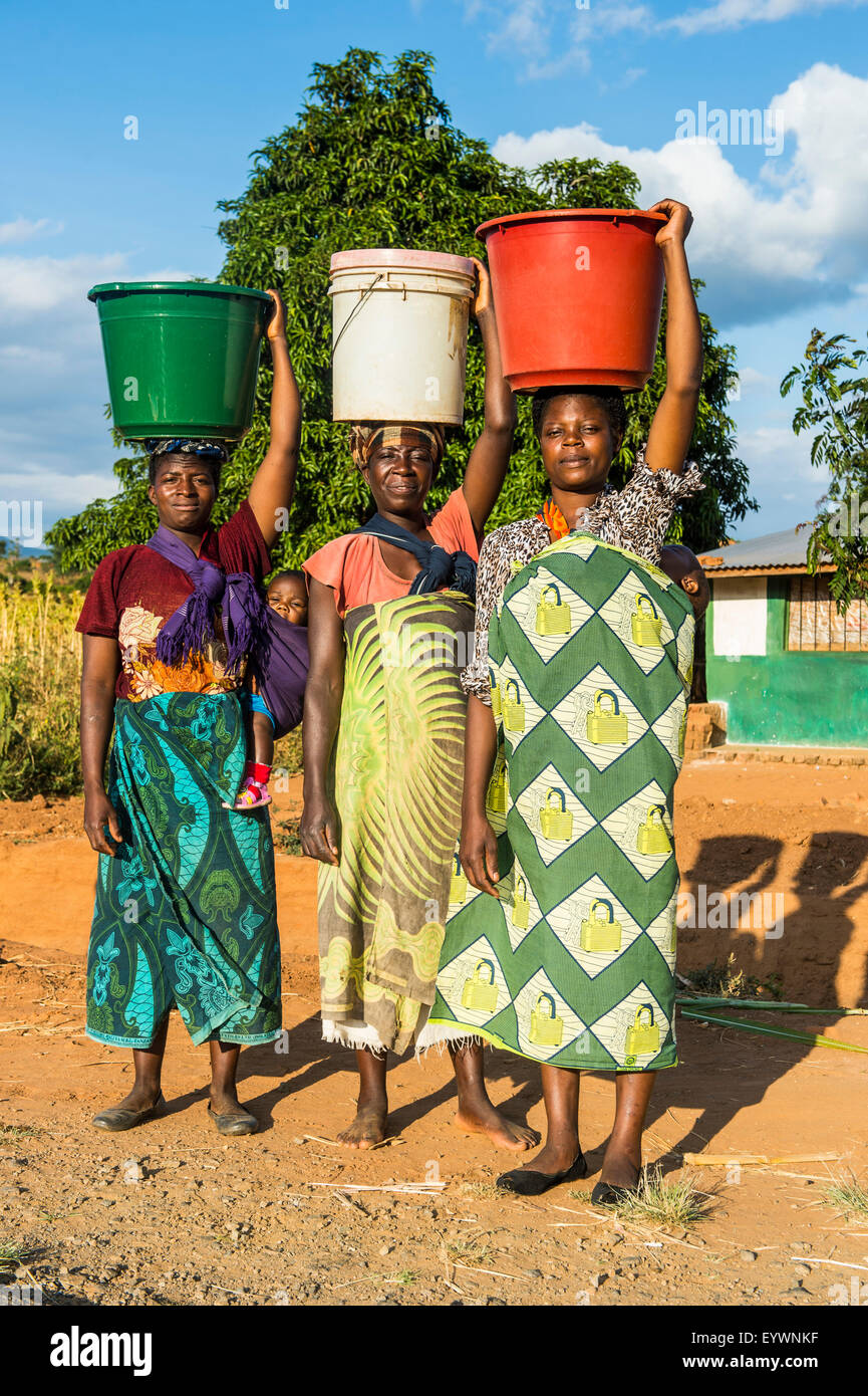 Local women carrying buckets on their heads, Malawi, Africa Stock Photo