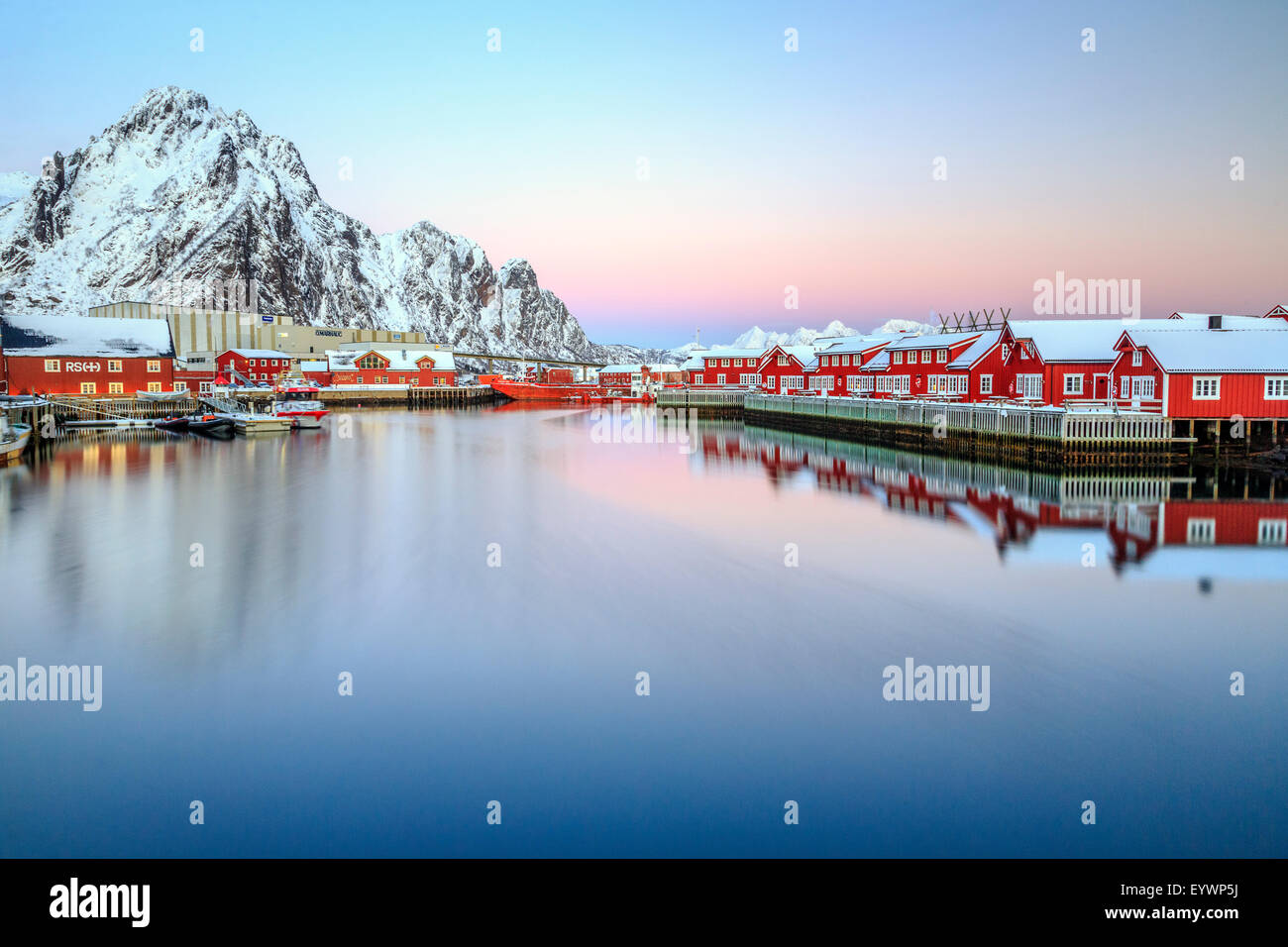 Pink sunset over the typical red houses reflected in the sea, Svolvaer, Lofoten Islands, Norway, Arctic, Scandinavia, Europe Stock Photo