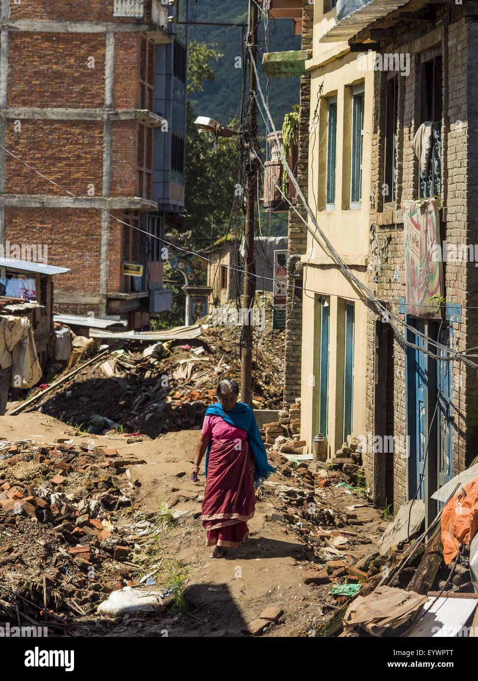 Sankhu, Central Region, Nepal. 3rd Aug, 2015. A woman walks down a street still strewn with debris from the earthquake in Sankhu, a community about 90 minutes from central Kathmandu. The Nepal Earthquake on April 25, 2015, (also known as the Gorkha earthquake) killed more than 9,000 people and injured more than 23,000. It had a magnitude of 7.8.  It was the worst natural disaster to strike Nepal since the 1934 Nepal''“Bihar earthquake. © ZUMA Press, Inc./Alamy Live News Stock Photo