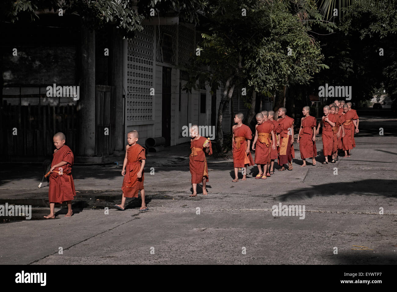 Group of young Thai monks en-route to evening prayers. Thailand S. E. Asia Stock Photo