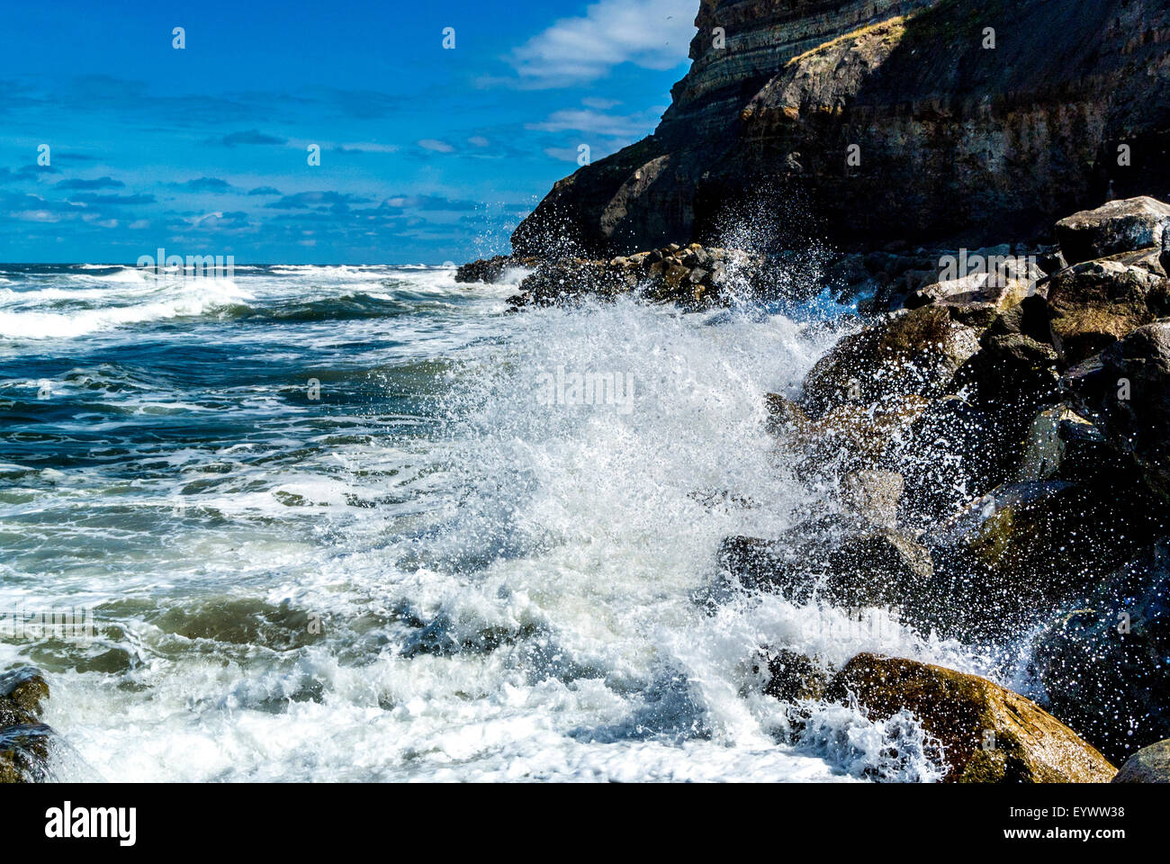 Ocean waves breaking onto rocks. Whitby. Stock Photo