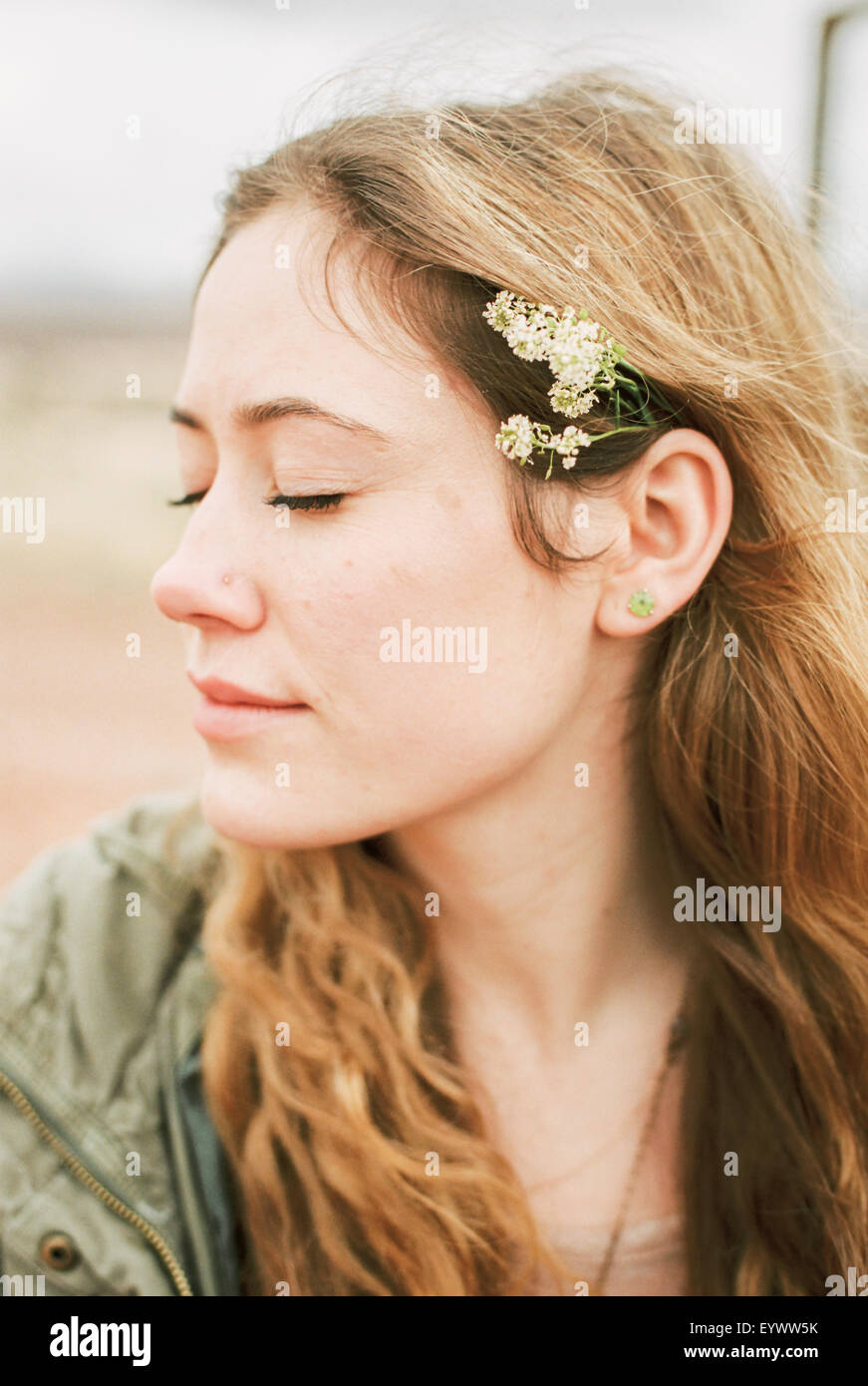 Head and shoulders portrait of a woman with a flower in her hair. Stock Photo