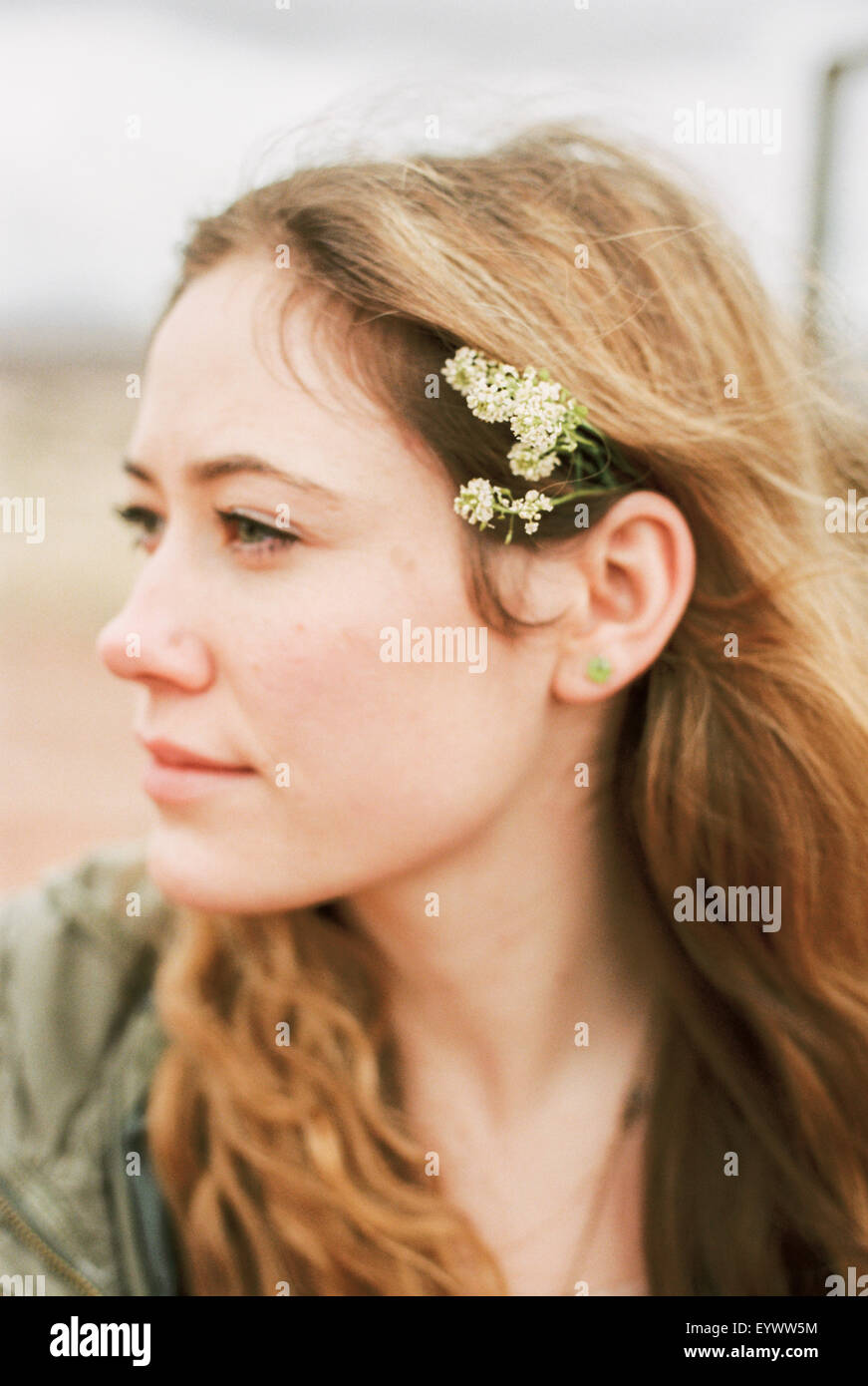 Head and shoulders portrait of a woman with a flower in her hair. Stock Photo