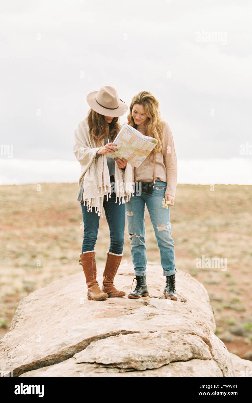 Two women standing in a desert, studying a map. Stock Photo