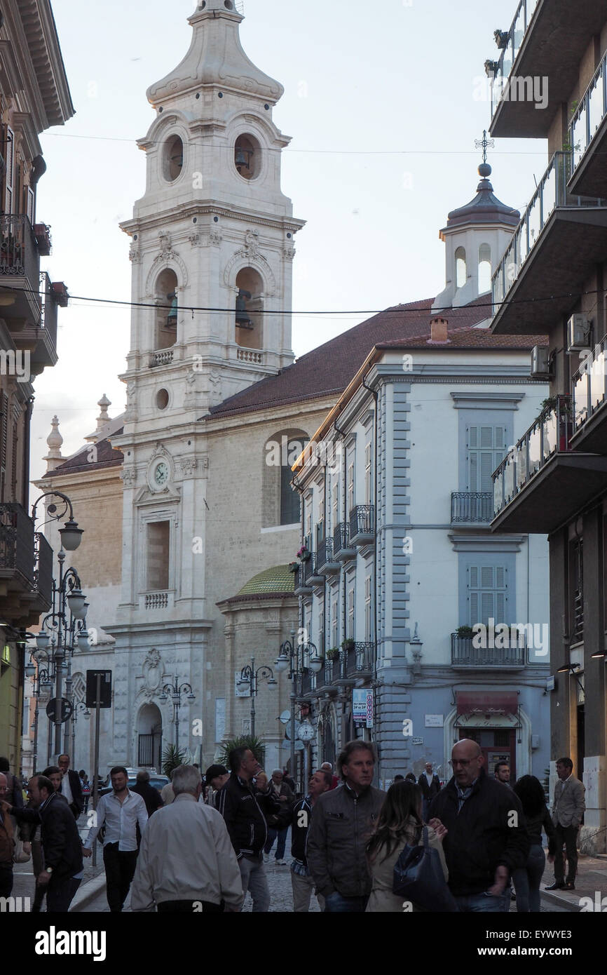People going on their evening walk in Foggia with the Church of Our Lady of the Assumption in the background. Stock Photo