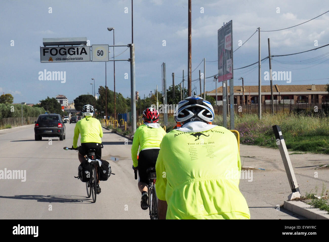 Three touring cyclists riding into the city of Foggia, Italy. Stock Photo