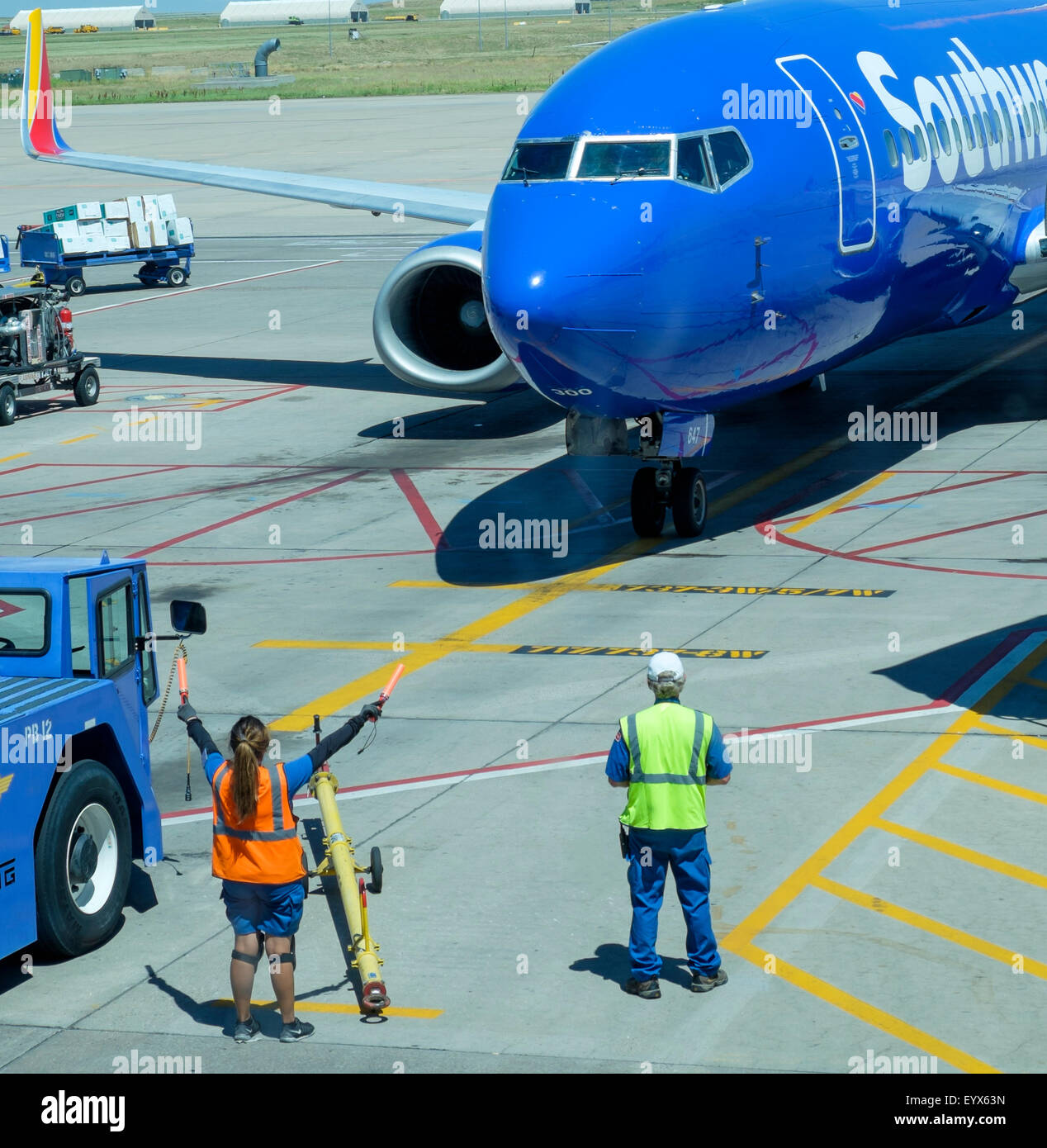 Female ground crew member directing Southwest Airlines jet to terminal