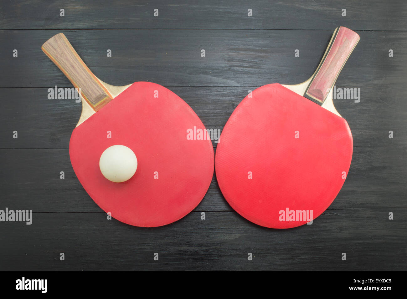 Pair of red table tennis paddles on dark background Stock Photo
