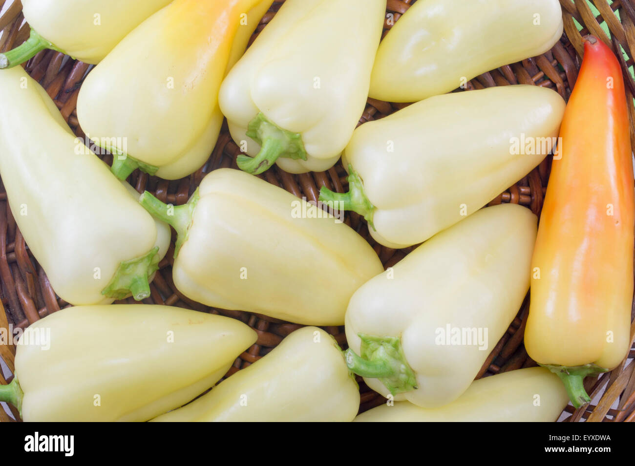 Natural green and orange chili peppers arranged on a wooden plate Stock Photo