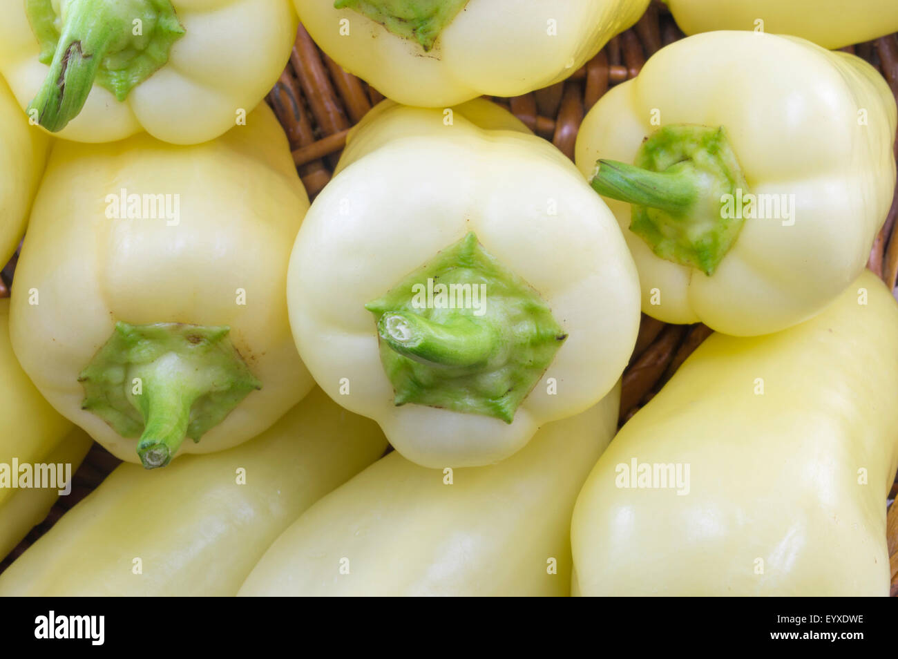 Natural green and orange chili peppers arranged on a wooden plate front view close up Stock Photo