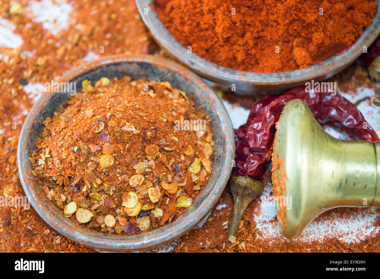 Different form of paprika. Dried grounded, chopped and whole peppers in natural wooden bowls