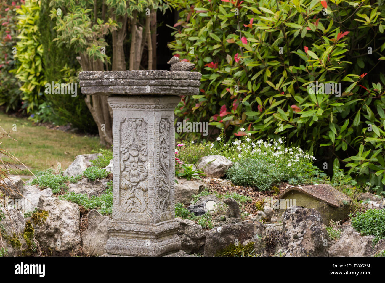 Birdbath in garden with rockery Stock Photo - Alamy