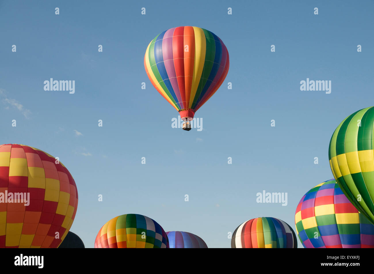 A single hot-air balloon floating above others at a balloon festival Stock Photo