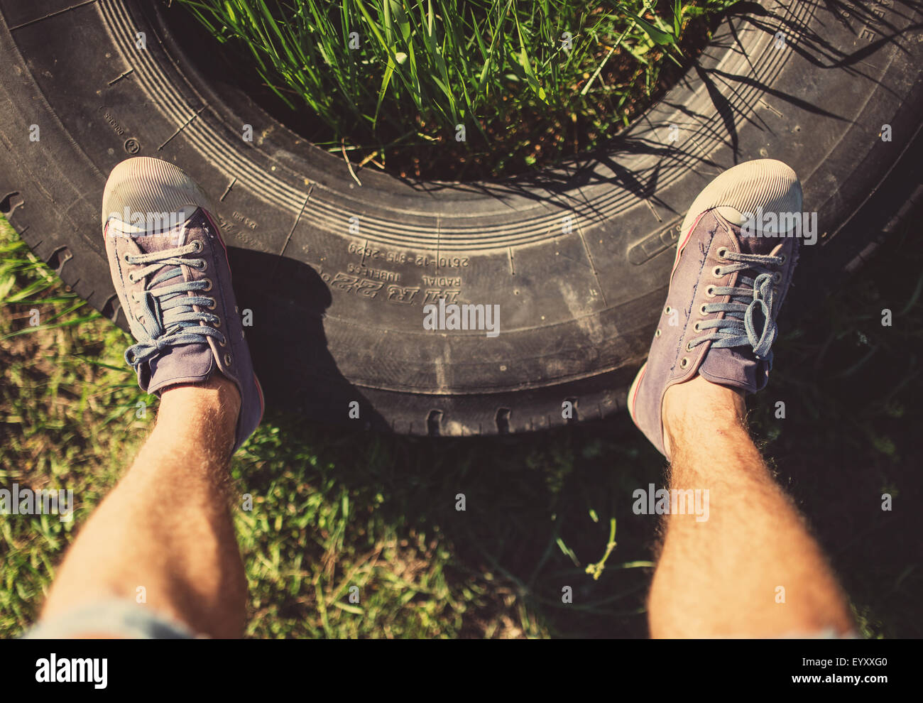 Man standing on old tire, tinted photo Stock Photo