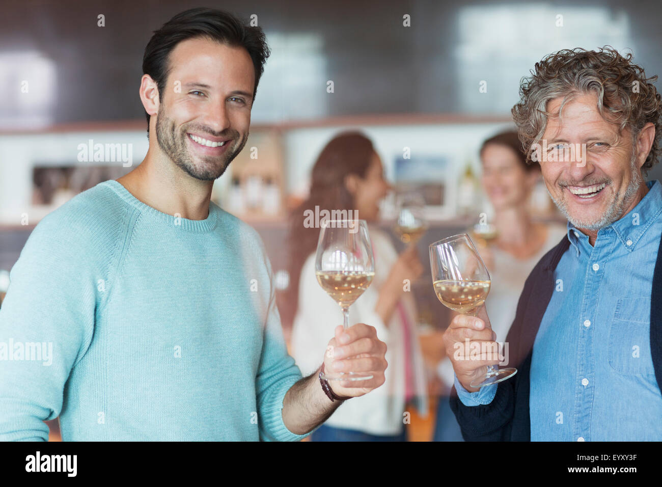 Portrait smiling men wine tasting at winery tasting room Stock Photo