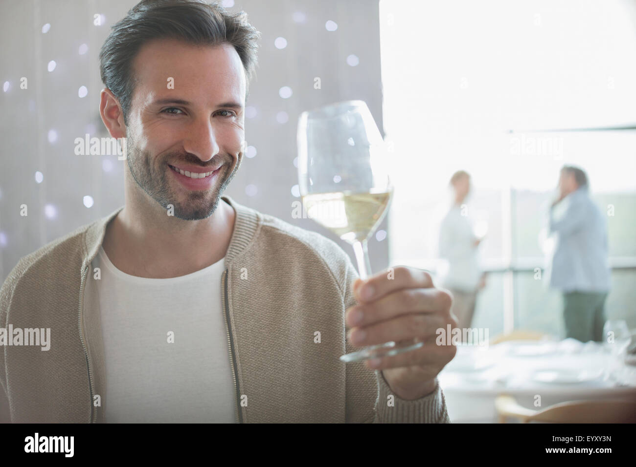 Portrait smiling man drinking white wine in restaurant Stock Photo - Alamy