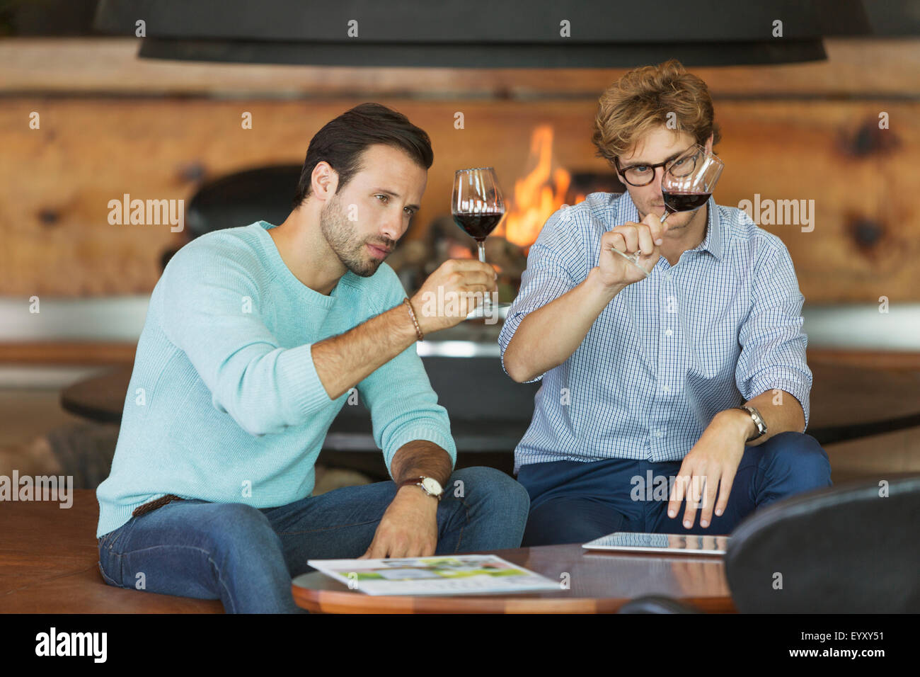 Men wine tasting red wine in winery tasting room Stock Photo