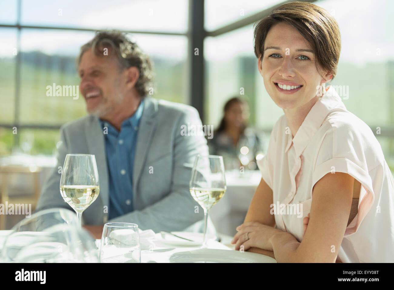 Portrait smiling woman drinking wine in sunny restaurant Stock Photo