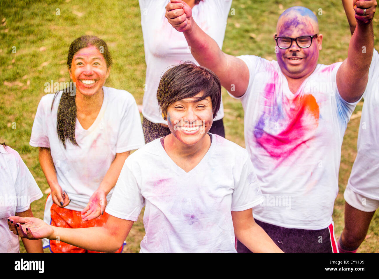 Smiling friends covered in pigment powder cheering Stock Photo