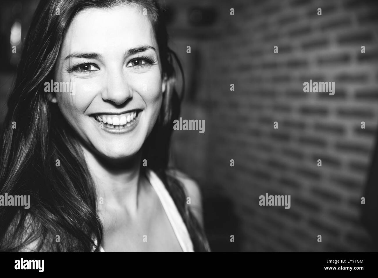 Smiling Caucasian woman laughing in nightclub Stock Photo