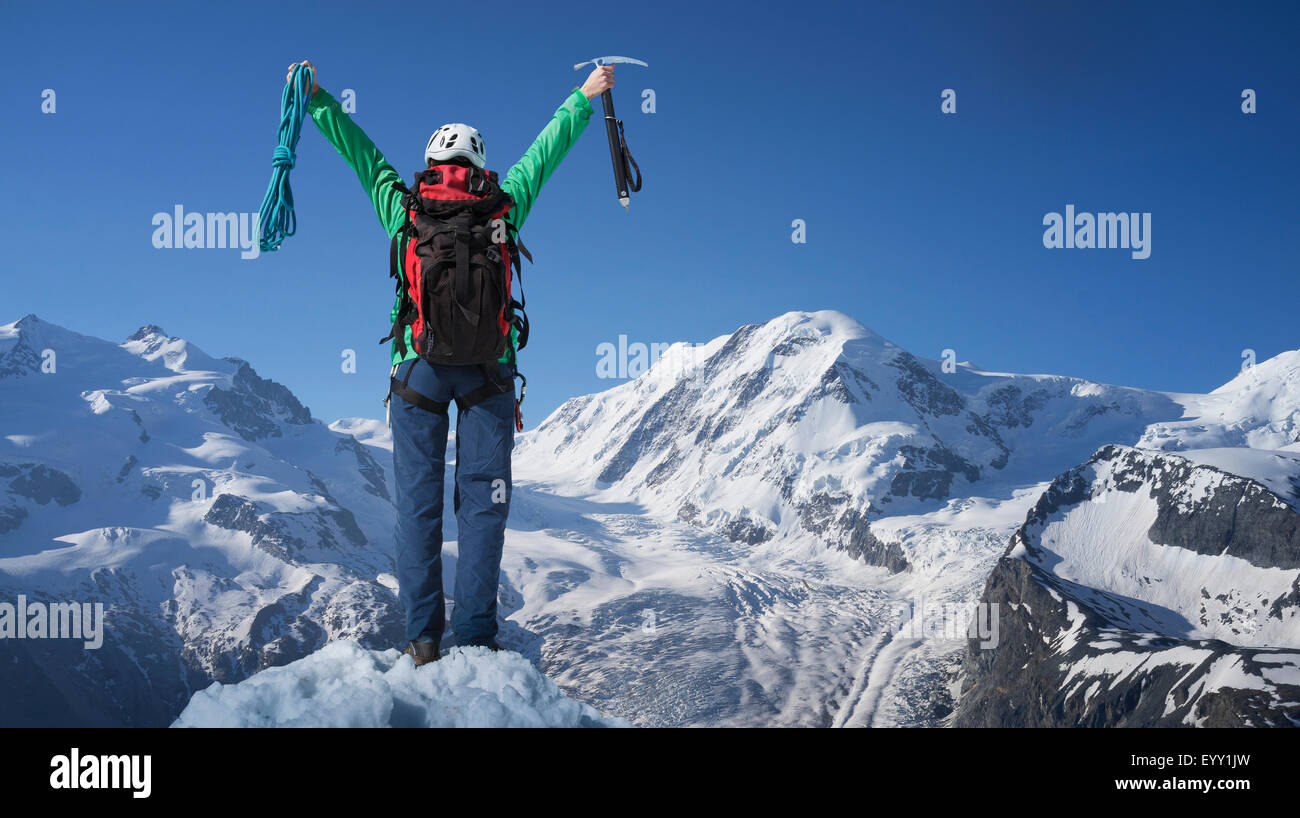 Caucasian hiker cheering on mountaintop, Monte Rosa, Alps, Italy Stock Photo