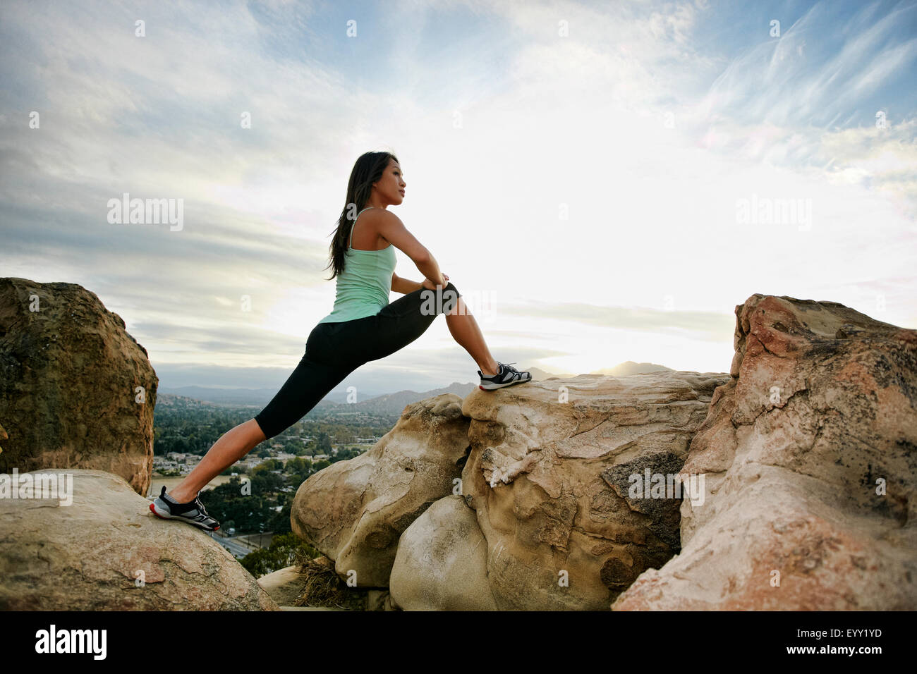 Vietnamese woman stretching on rocky hilltop Stock Photo Alamy