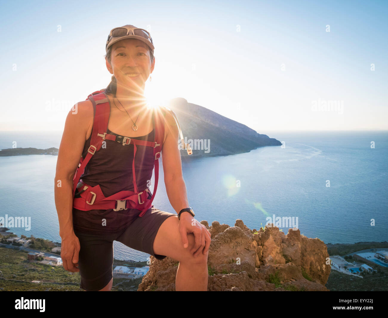 Japanese hiker standing on hilltop over ocean Stock Photo