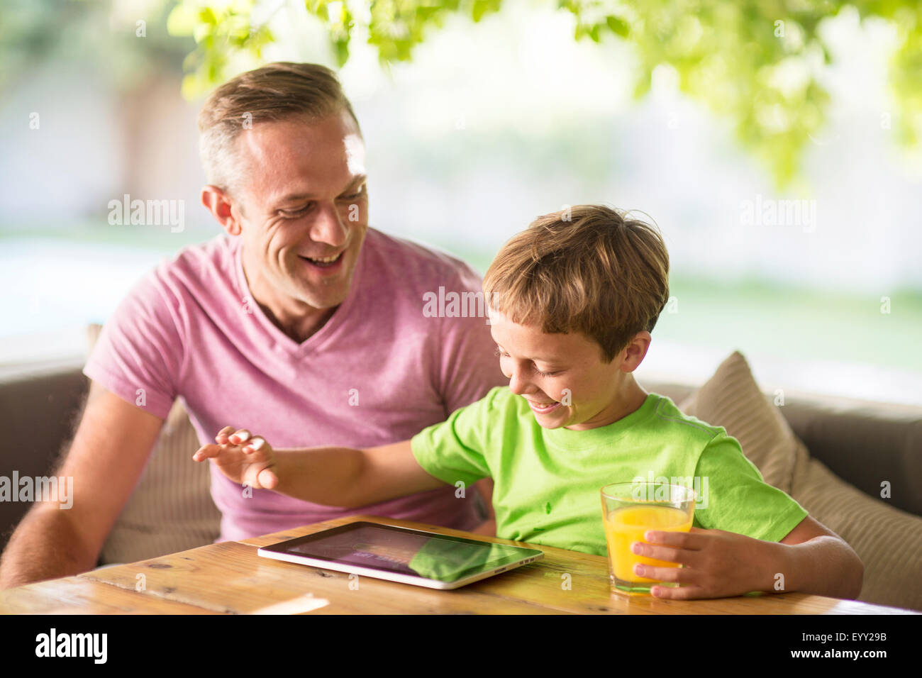 Caucasian father and son using digital tablet outdoors Stock Photo