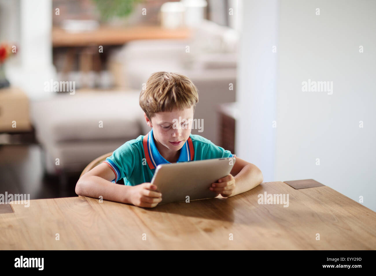 Caucasian boy using digital tablet at table Stock Photo