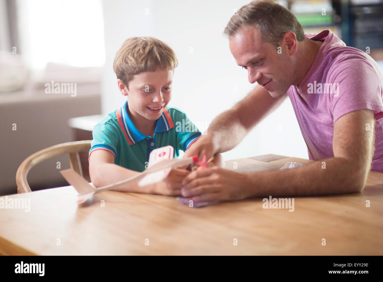 Caucasian father and son examining model airplane at table Stock Photo