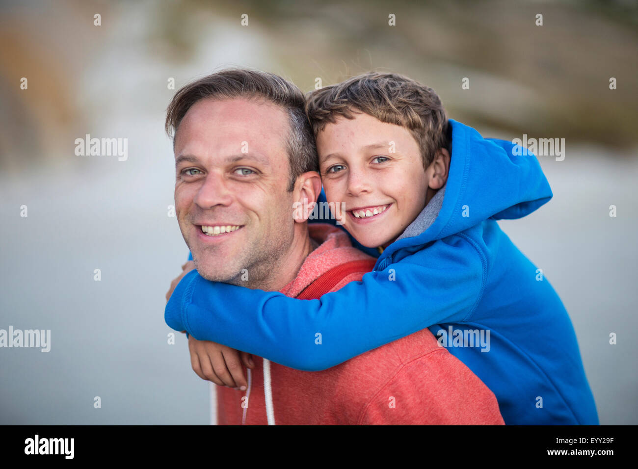 Caucasian father carrying son piggyback outdoors Stock Photo