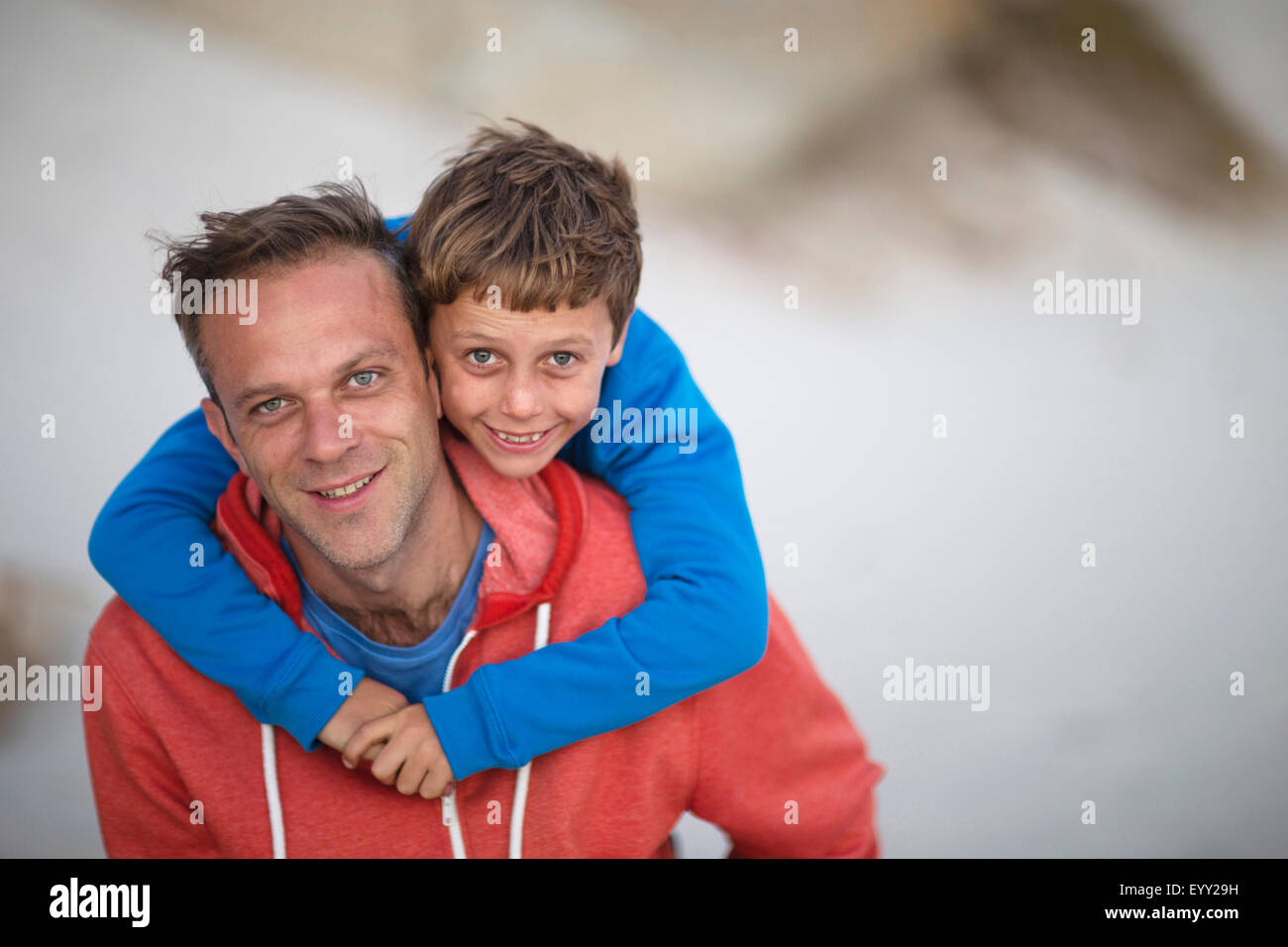 Caucasian father carrying son piggyback outdoors Stock Photo