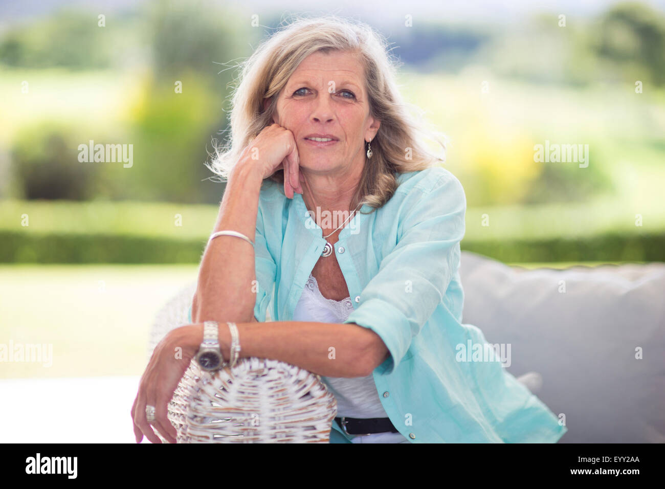 Caucasian woman sitting on sofa outdoors Stock Photo
