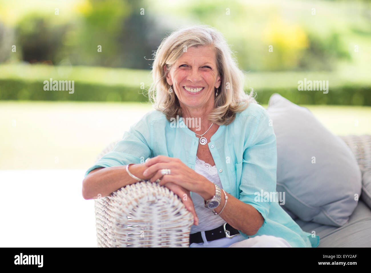 Caucasian woman sitting on sofa outdoors Stock Photo