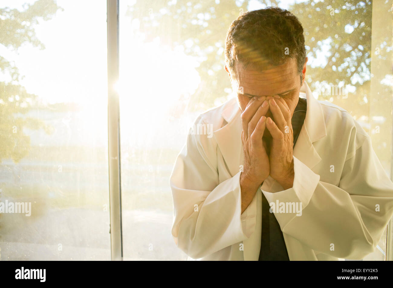 Stressed Hispanic doctor rubbing his eyes Stock Photo