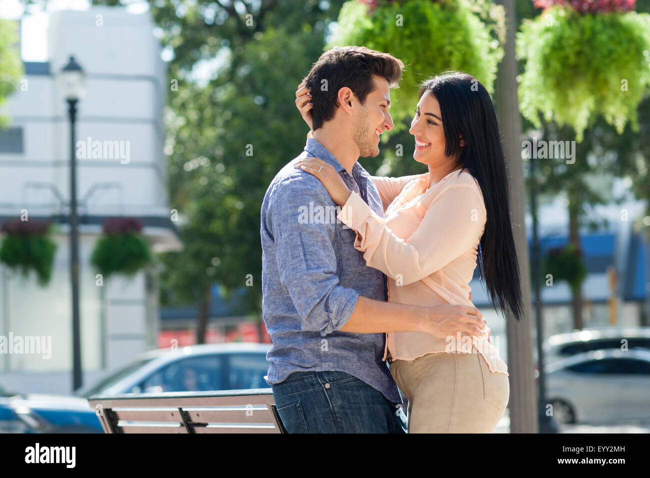 Hispanic couple hugging in urban park Stock Photo - Alamy