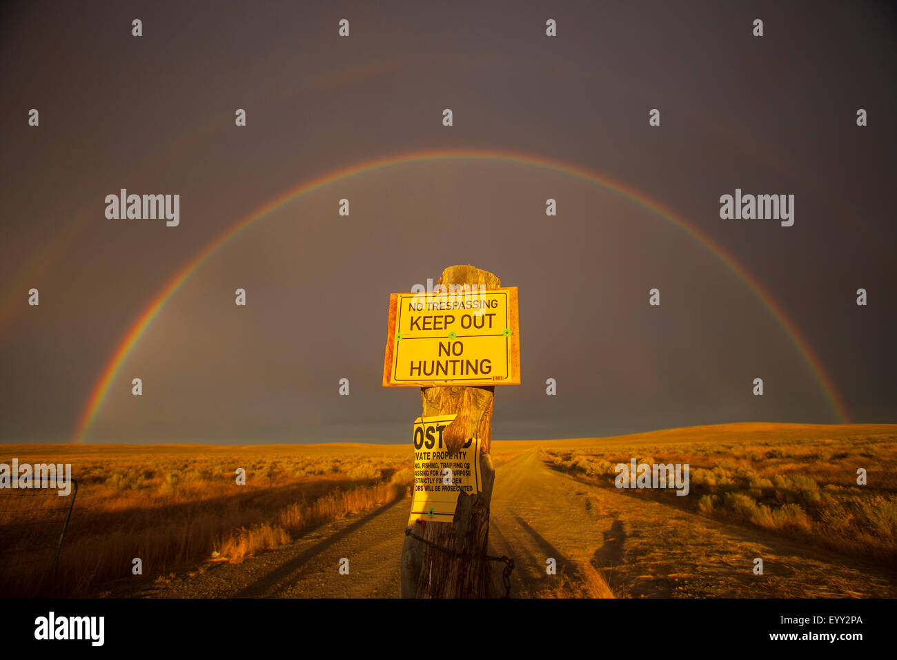 Warning sign in private fields under rainbow Stock Photo