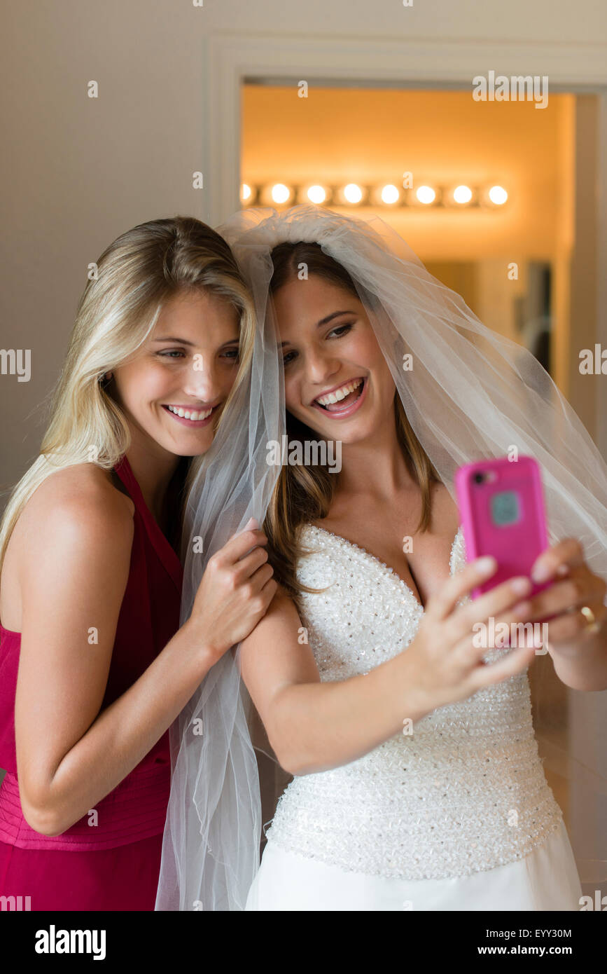 Caucasian bride and bridesmaid taking selfie Stock Photo