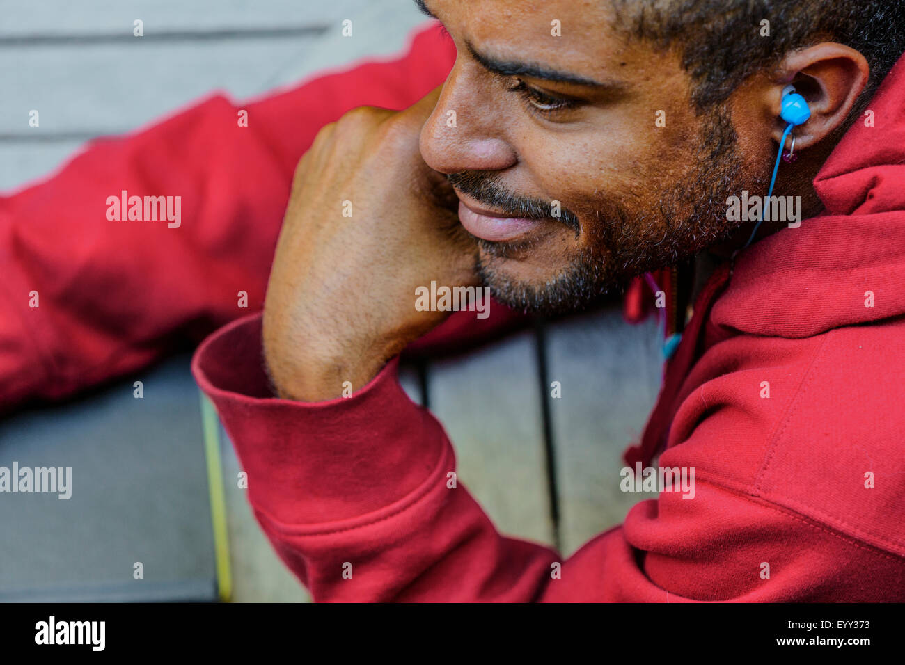 Close up of mixed race man listening to earbud Stock Photo